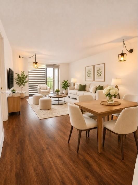 Living area featuring wood-finish flooring, two matte black wall-mounted lantern light fixtures, and a glass-paned sliding door