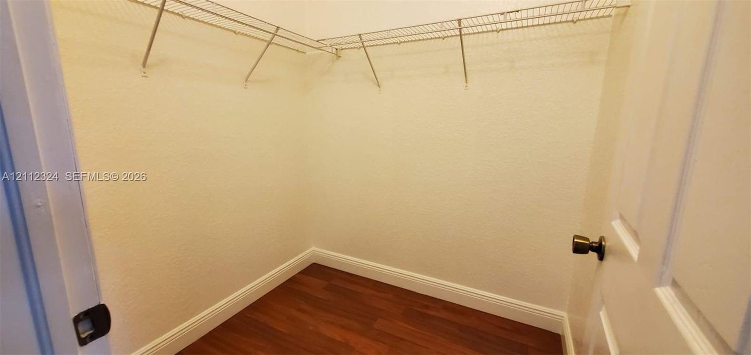 Storage area featuring wood-finish flooring and wire shelving