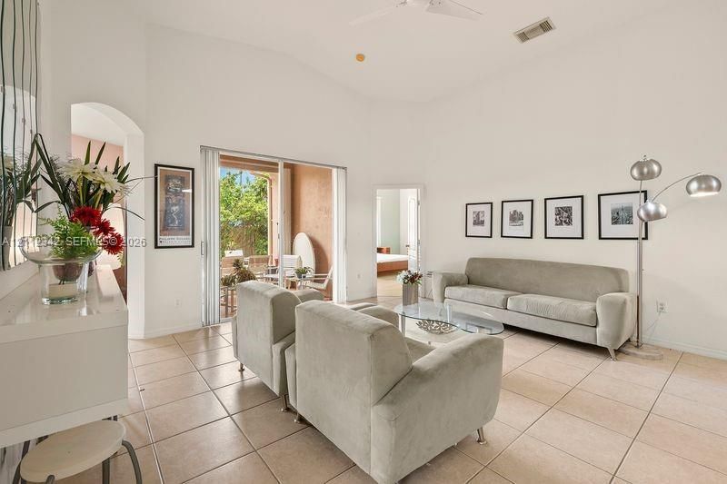 Living area featuring vaulted ceilings, tile flooring, and sliding glass doors providing outdoor access