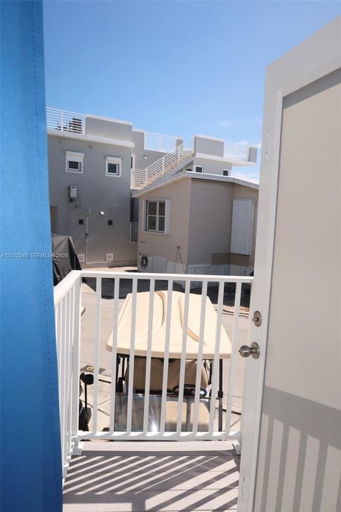 Elevated balcony featuring a white metal railing and composite decking