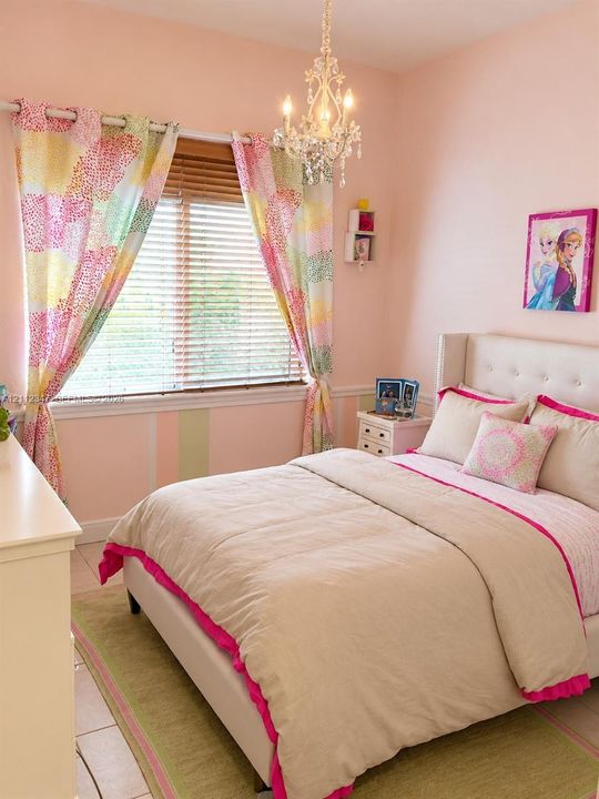 Bedroom featuring a crystal-style chandelier, horizontal window blinds, and tile flooring