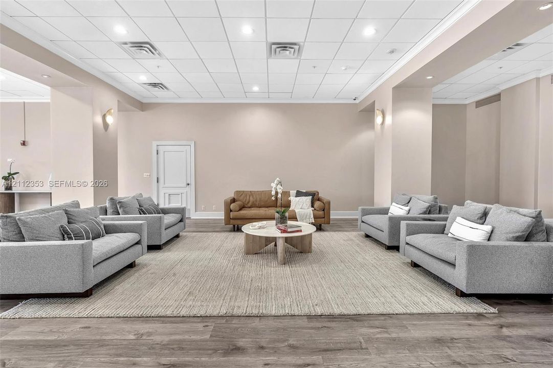 Expansive open-concept space featuring high ceilings with recessed lighting, wood-finish flooring, and neutral wall tones