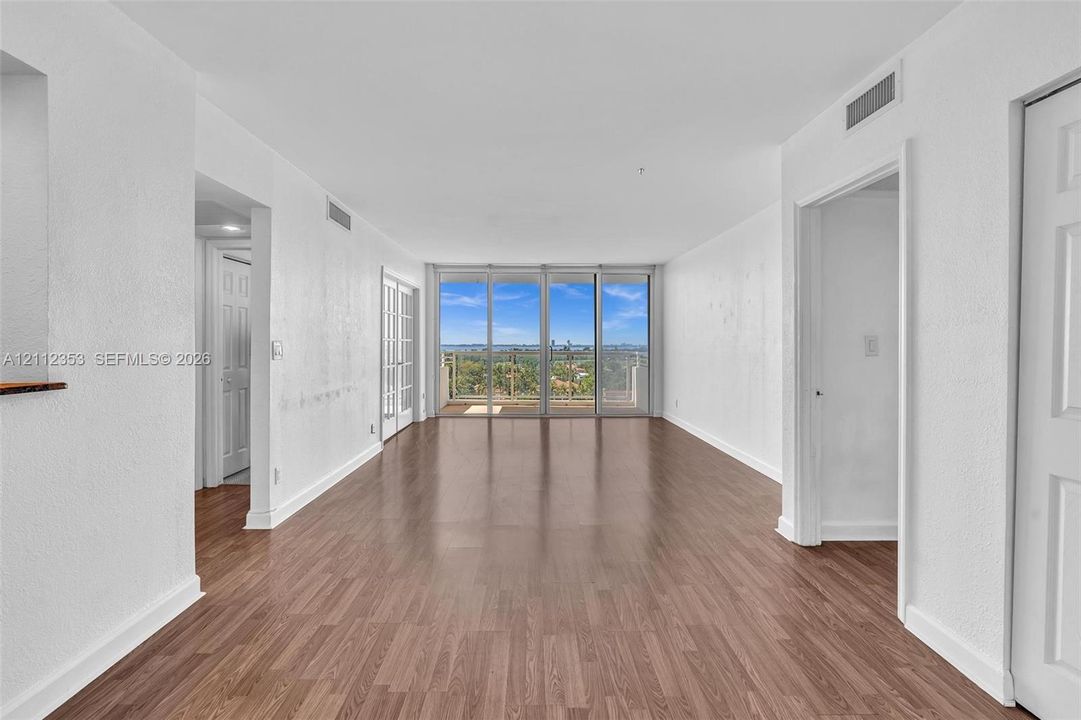 Interior space featuring wood-finish flooring, floor-to-ceiling glass sliding doors, and a private balcony