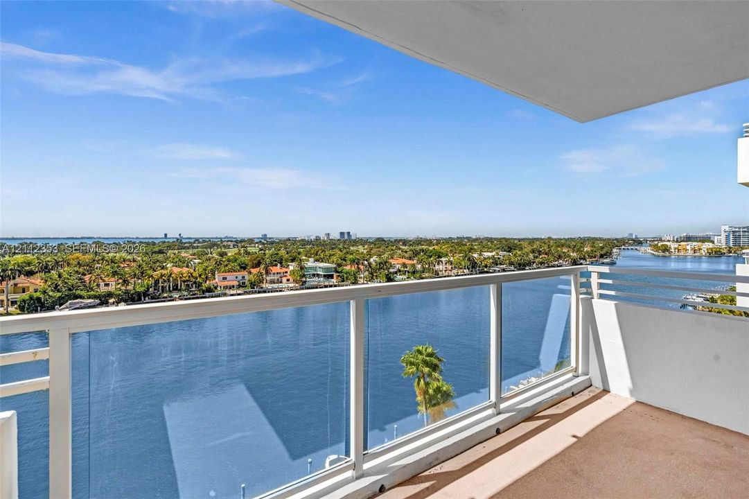 Covered balcony featuring glass paneled railings and concrete flooring