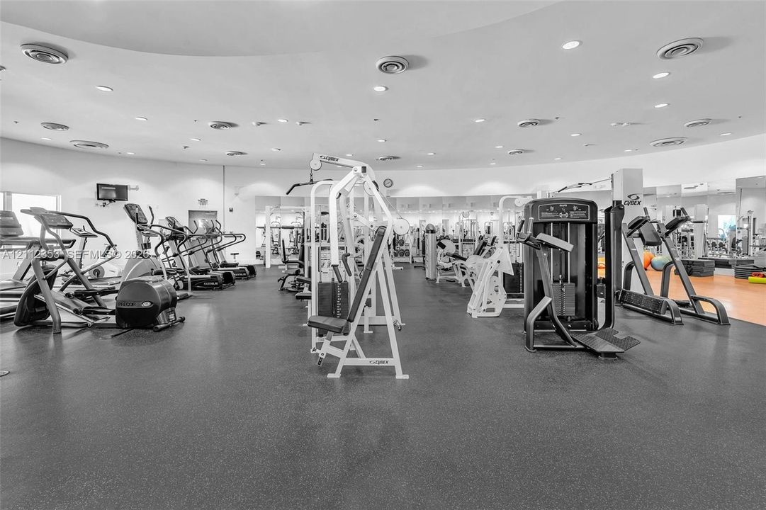 Fitness room featuring rubberized flooring, recessed ceiling lighting, and wall-to-wall mirrored surfaces
