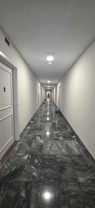 Polished stone tile flooring, neutral wall finishes, and recessed ceiling lighting