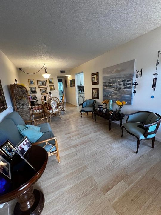 Open-concept interior featuring wood-finish flooring and a central pendant lighting fixture
