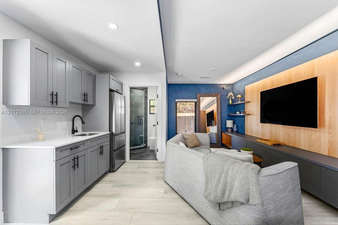 Kitchenette featuring grey shaker-style cabinetry, white countertops, and a matte black faucet