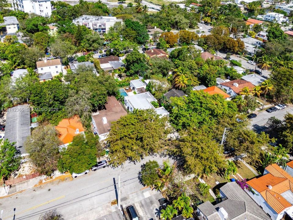 Aerial perspective featuring a property with a swimming pool and mature perimeter vegetation