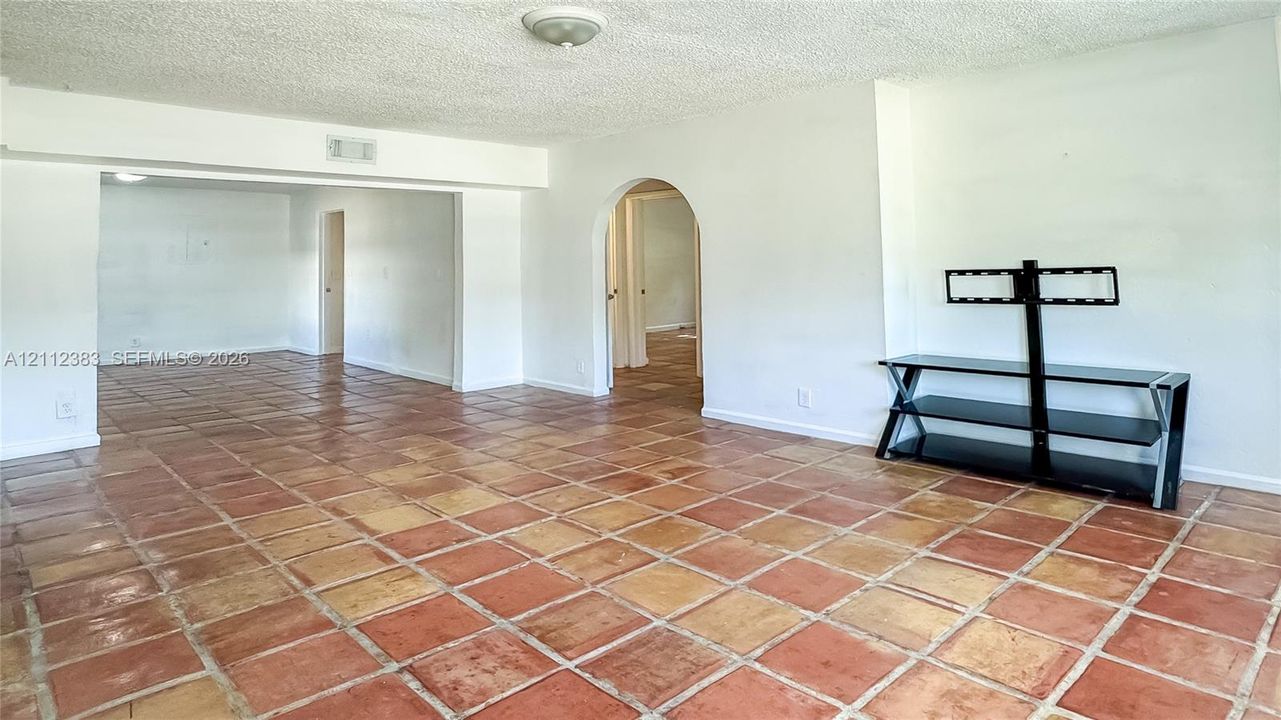 Interior space featuring terra cotta tile flooring and an arched entryway