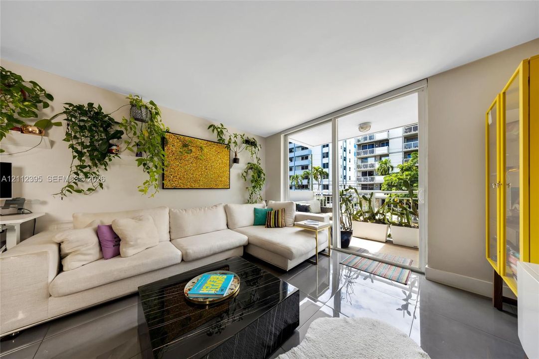 Living area featuring polished tile flooring, sliding glass doors, and a private balcony
