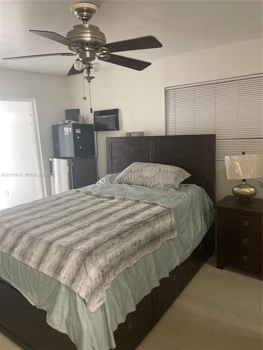 Ceiling fan with integrated lighting, horizontal window blinds, and tile flooring