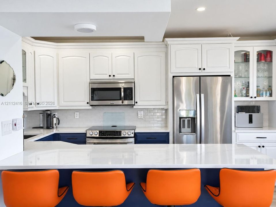 Updated Kitchen featuring new cabinetry, stainless steel appliances, and counter top dining.