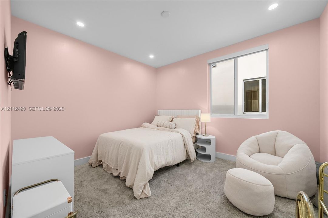 Neutral-toned carpeting, recessed ceiling lighting, and a single-pane window