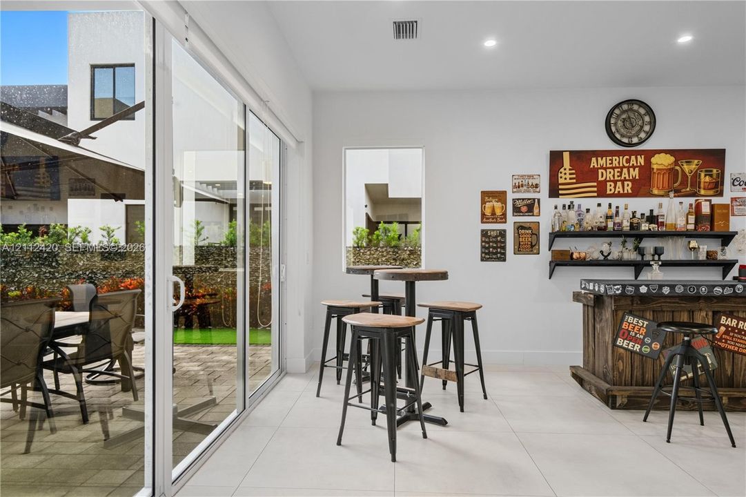 Large-format sliding glass doors, neutral tile flooring, recessed ceiling lighting, and a fixed vertical window