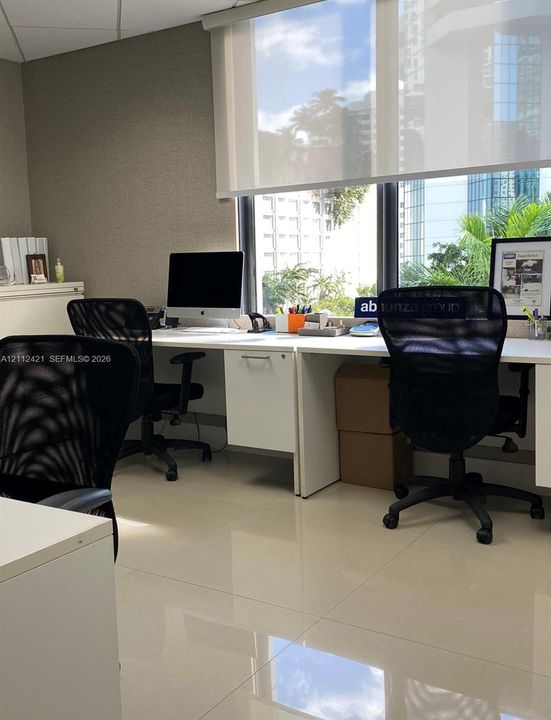 Built-in white laminate cabinetry, polished tile flooring, and floor-to-ceiling windows with retractable solar shades