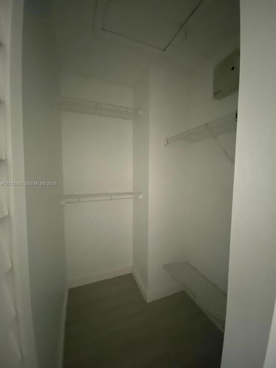 Storage area featuring wire shelving and wood-finish flooring