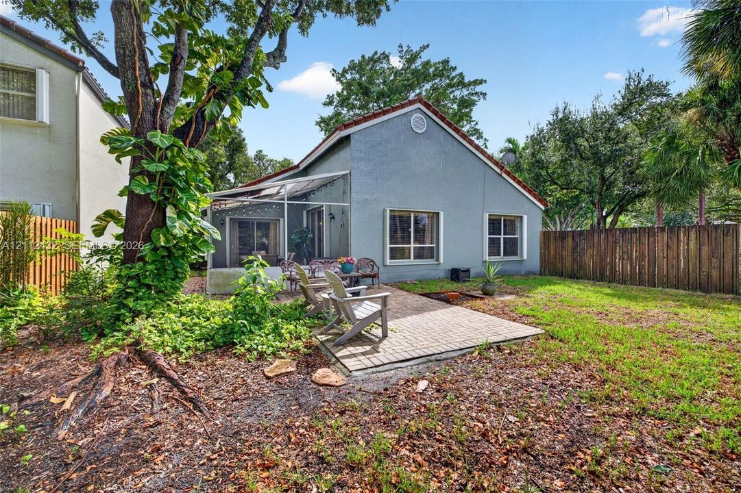 Backyard featuring a paved patio, screened enclosure