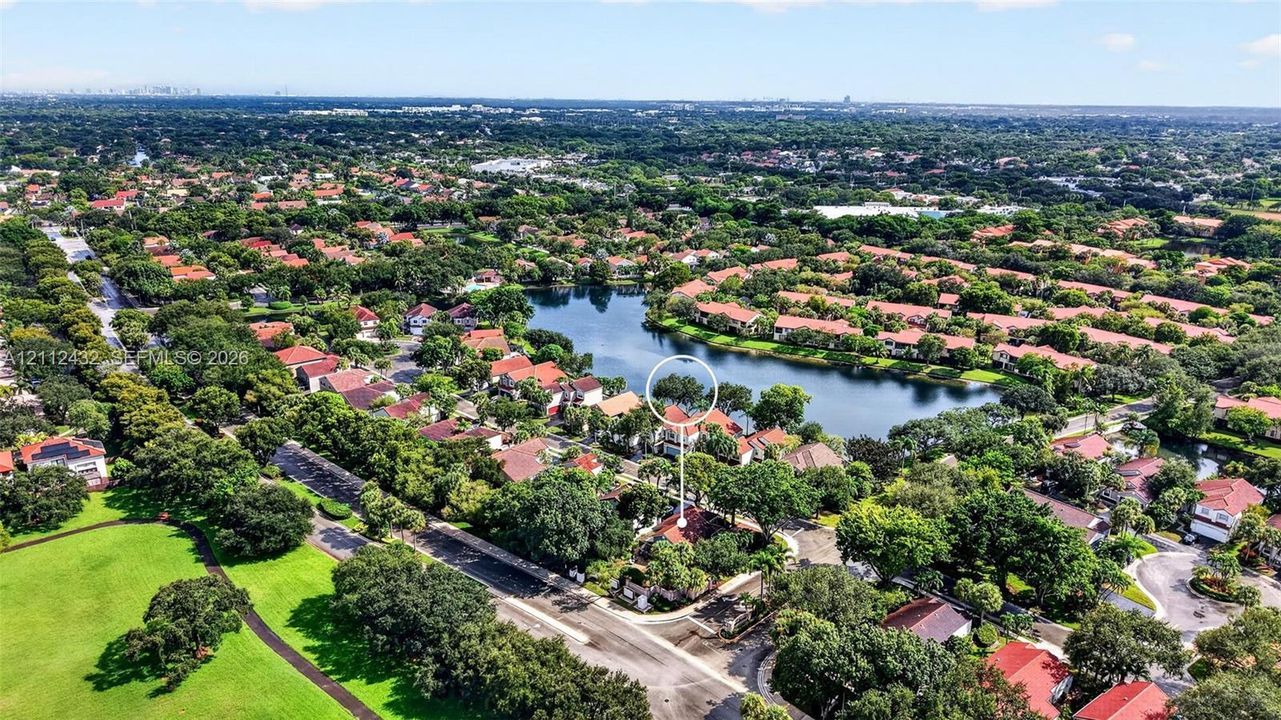 Check out proximity to Downtown Fort Lauderdale on the left. Aerial perspective featuring a residential property situated on a lakefront lot with mature trees and proximity to open green space