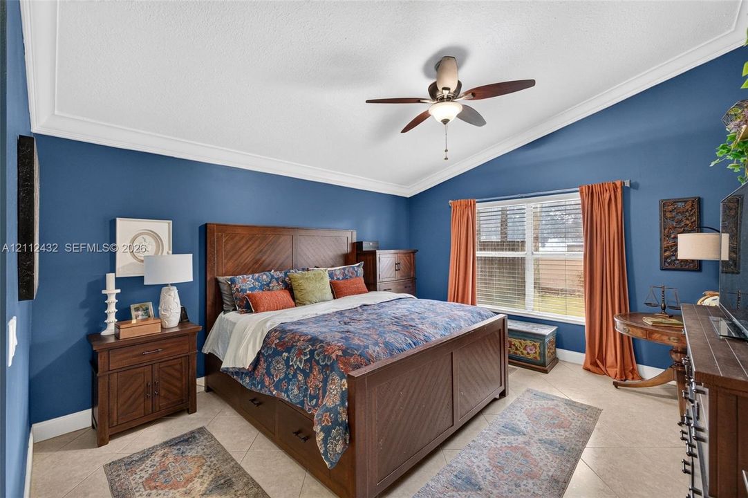 Vaulted ceilings, crown molding, ceramic tile flooring, and a central ceiling fan