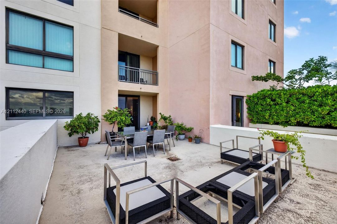 Expansive outdoor terrace featuring concrete flooring, a covered recessed area, and low-profile concrete perimeter walls