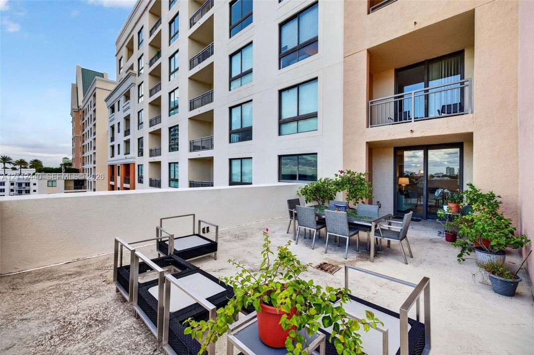 Expansive private terrace featuring a solid-surface floor, perimeter concrete walls, and large glass-panel sliding doors