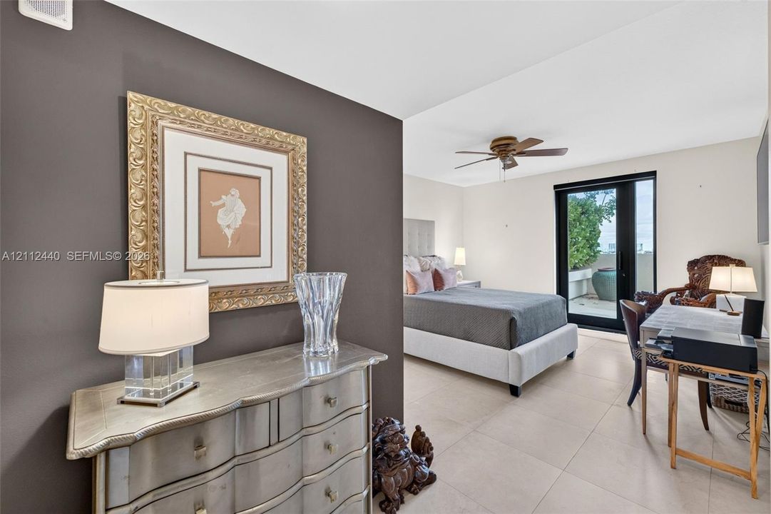 Large-format porcelain flooring, ceiling fan with integrated lighting, and glass-paned exterior door with access to private balcony