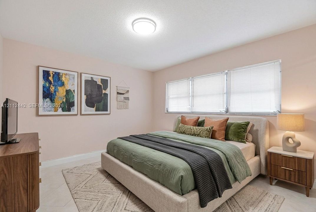 Bedroom featuring light-toned neutral wall paint, tile flooring, and horizontal window blinds