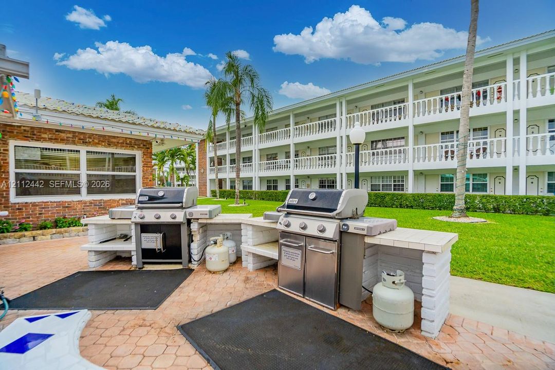 Outdoor grilling area featuring two stainless steel gas grills, built-in masonry counters, and paver patio flooring