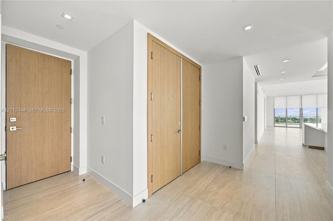 Solid wood-finish doors, large-format tile flooring, and recessed ceiling lighting