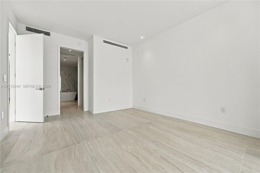 Large-format tile flooring, recessed ceiling lighting, and solid-core doors