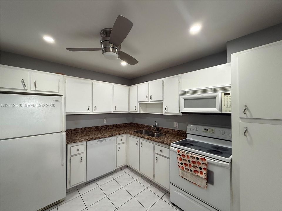 Kitchen featuring white cabinetry, speckled stone countertops, tiled flooring, recessed lighting, and a ceiling fan