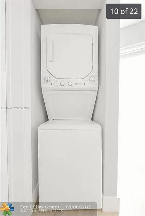 White stacked laundry unit contained within a recessed alcove