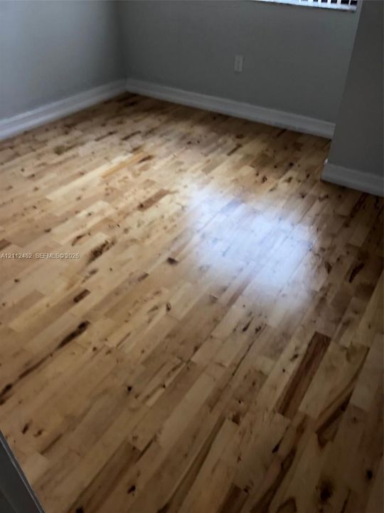 Light-toned wood-finish flooring featuring distinct natural graining and neutral-toned wall paint