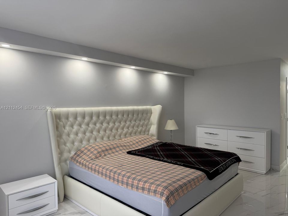 Neutral interior featuring light-toned flooring, recessed ceiling lighting, and a custom architectural soffit