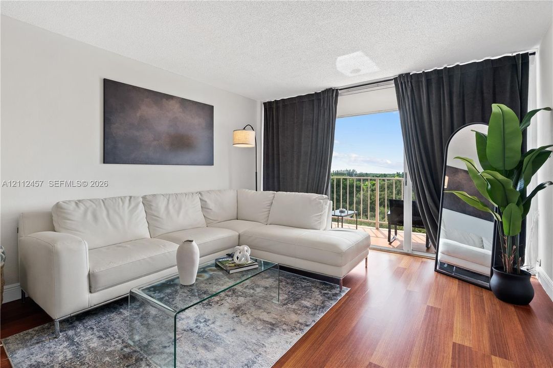 Living area featuring wood-finish flooring and sliding glass doors opening to a private balcony