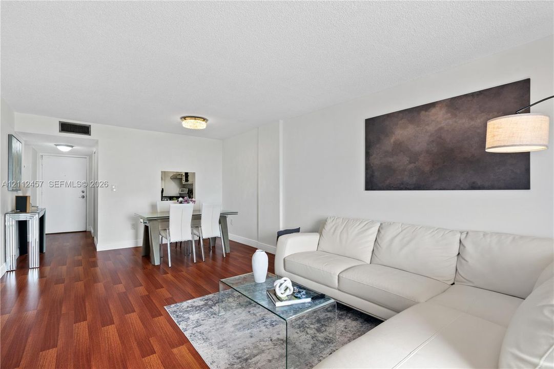 Living area featuring wood-finish flooring, recessed ceiling lighting, and a neutral color palette