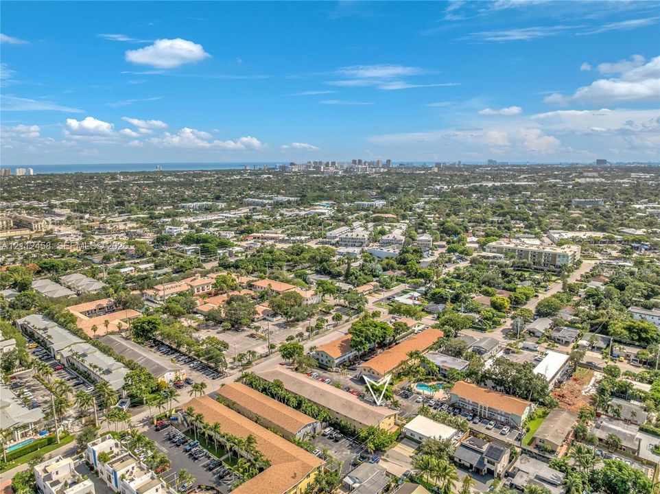 Aerial perspective of multi-family residential building featuring clay tile roofing and surface parking