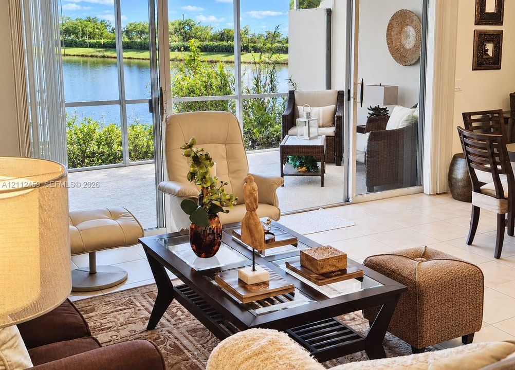 Screened-in patio with tile flooring and sliding glass door access, featuring water scenery
