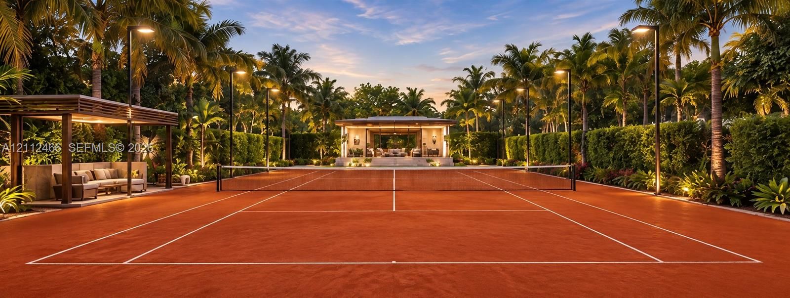 Professional-grade clay tennis court featuring perimeter post lighting, a private covered viewing pavilion, mature perimeter landscaping, and a detached structure