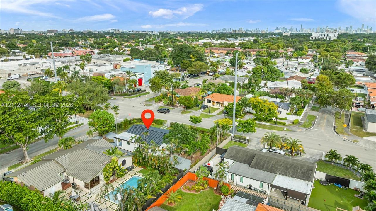 Aerial perspective featuring a metal roof, swimming pool, paved patio, and perimeter landscaping