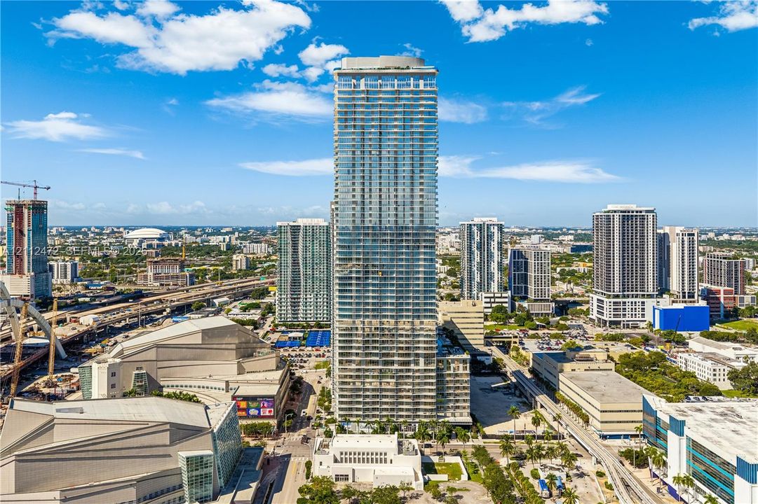 High-rise residential tower featuring a glass facade, multiple levels of private balconies, and a reinforced concrete structure