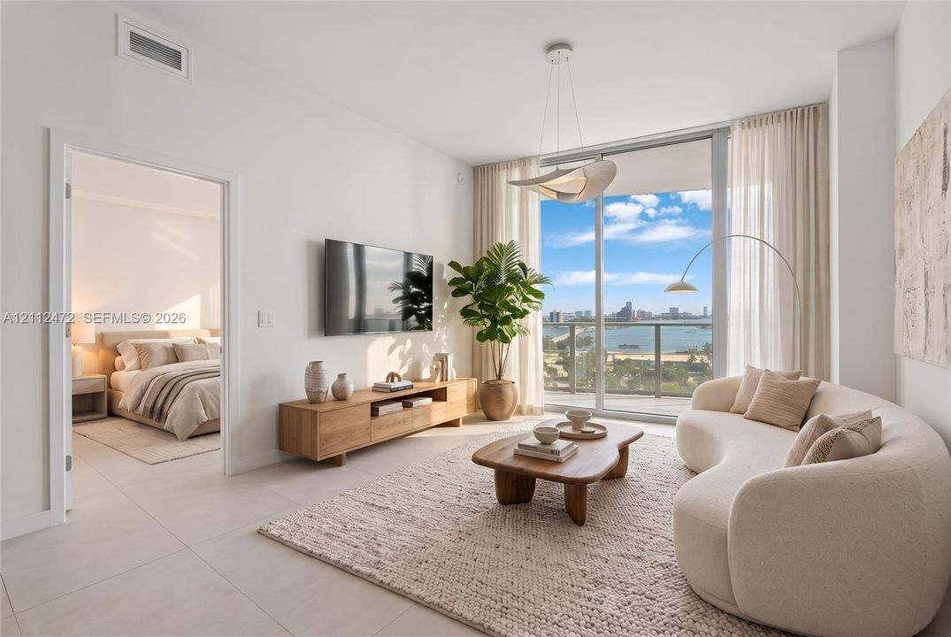 Floor-to-ceiling sliding glass doors, porcelain tile flooring, sculptural ceiling pendant lighting, and a private balcony featuring a water backdrop. VIRTUALLY STAGED