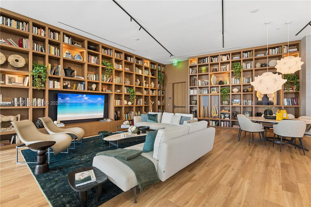 Floor-to-ceiling custom wood-finish built-in shelving, integrated accent lighting, track lighting, and wood-finish flooring