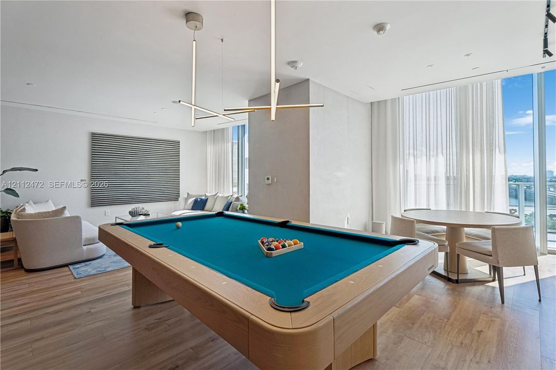 Floor-to-ceiling windows, wood-finish flooring, linear pendant lighting, and recessed ceiling lighting