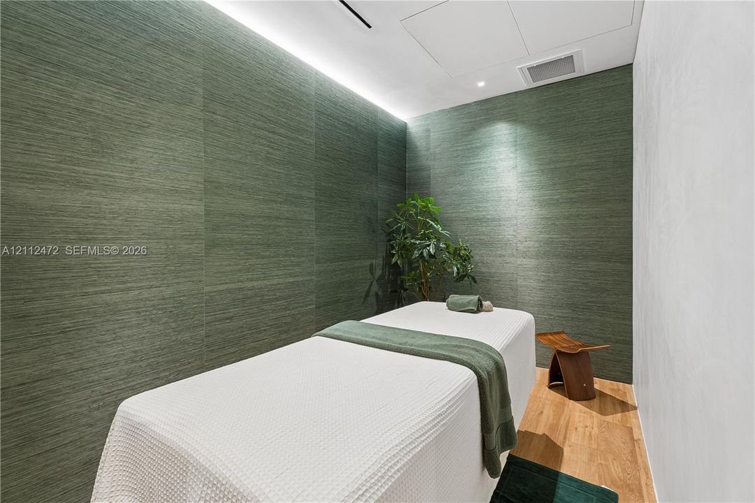 Textured forest-green wall panels, recessed ceiling lighting, and wood-finish flooring