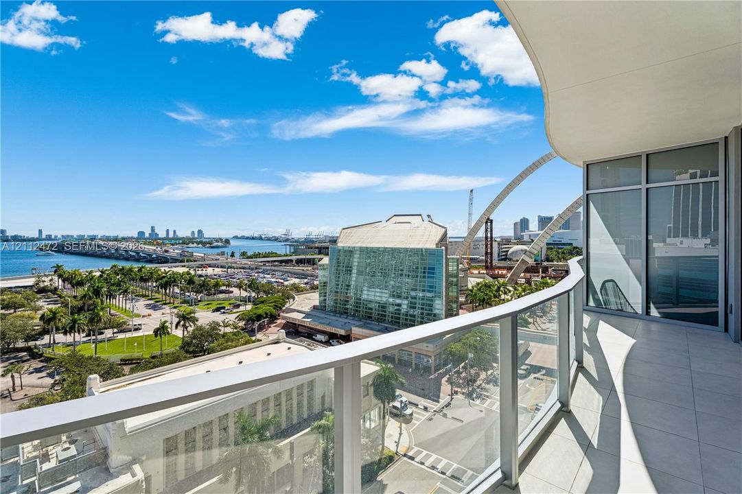 Covered balcony featuring tile flooring and a glass panel railing