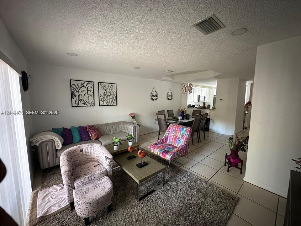 Living area featuring large-format tile flooring and recessed lighting