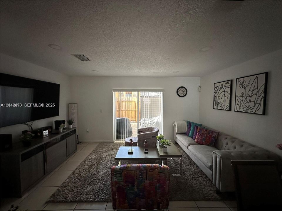 Neutral-toned tile flooring, recessed ceiling lighting, and sliding glass door with exterior access