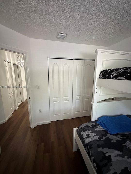Wood-finish flooring and white bi-fold closet doors